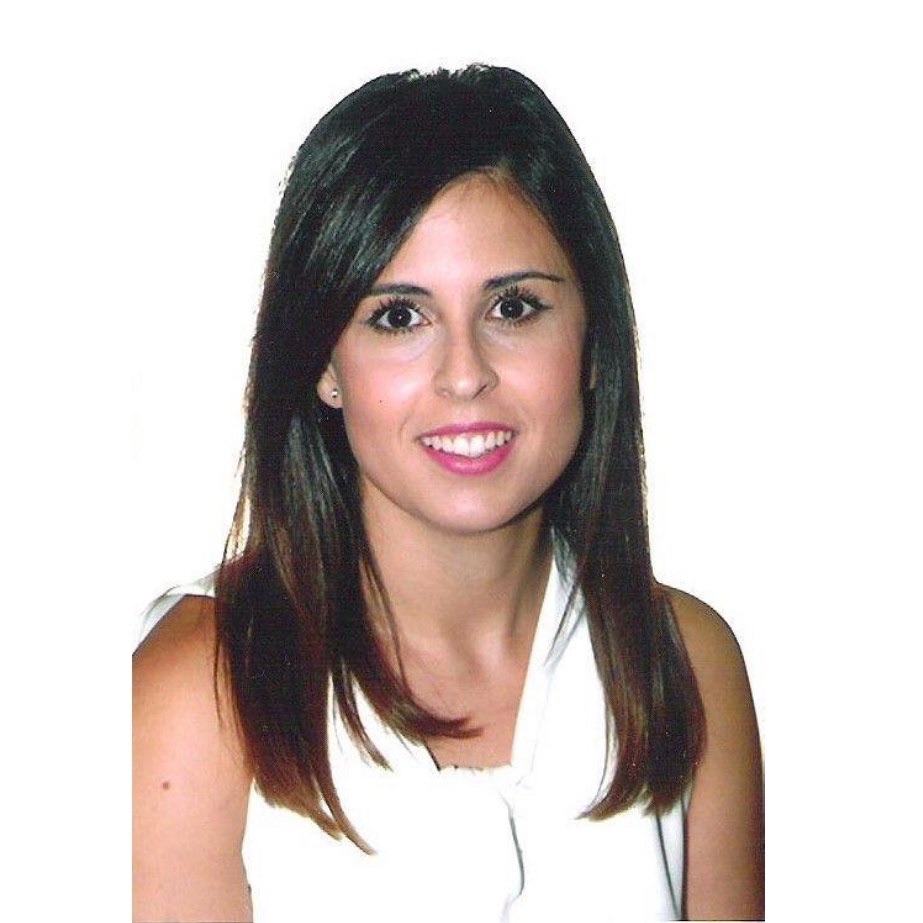 Mujer con cabello oscuro liso y blusa blanca sonríe sobre un fondo blanco.